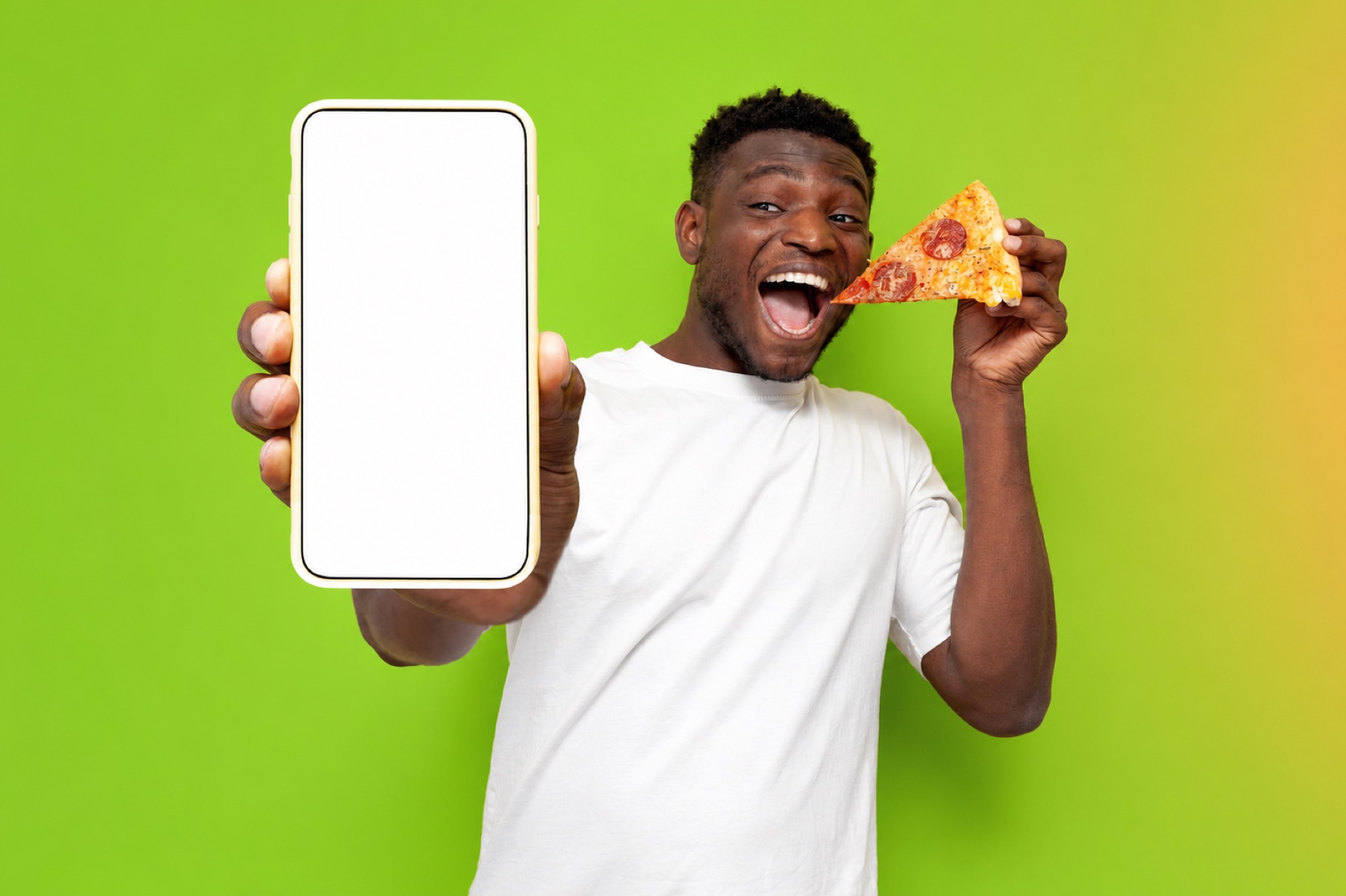 Smiling customer holding a smartphone and a slice of pizza