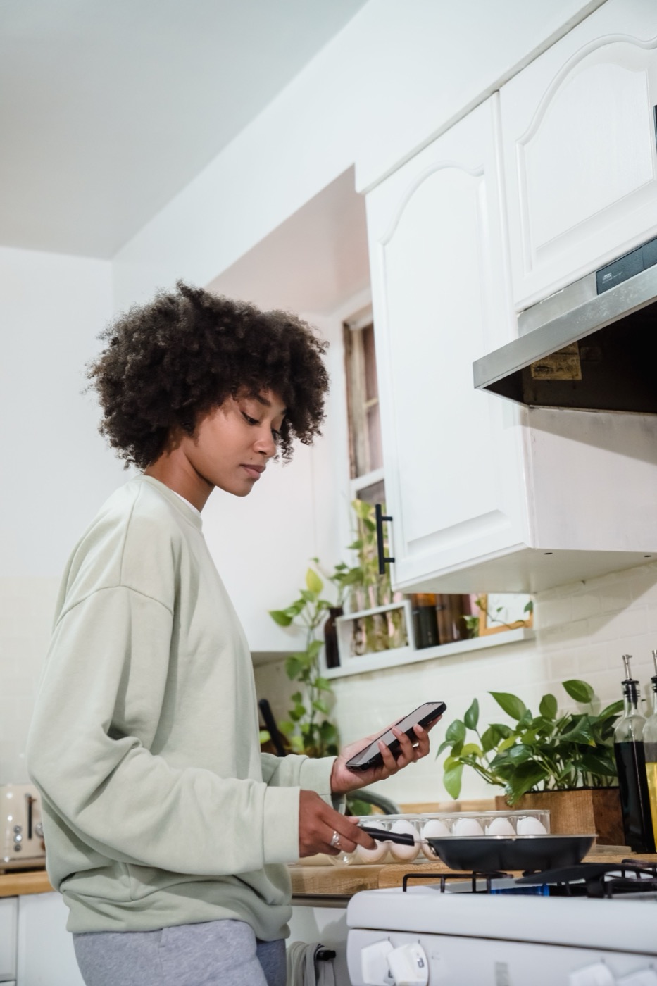 A kitchen owner preparing food while checking a phone